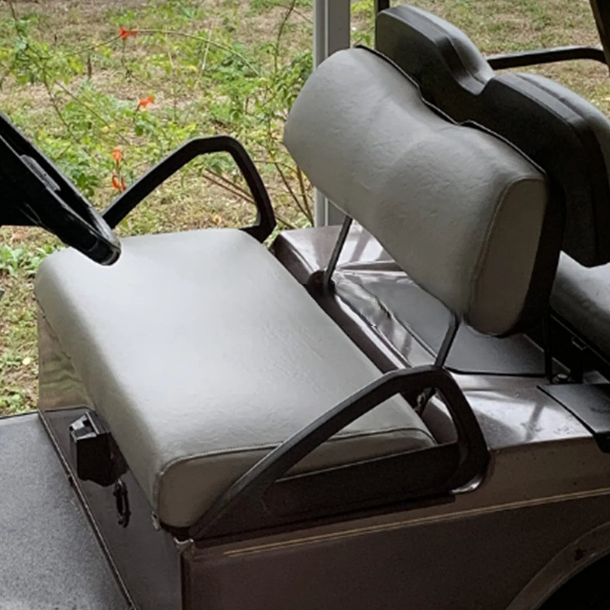 Tan upholstery shown on a golf cart bench and broad backrest from the side